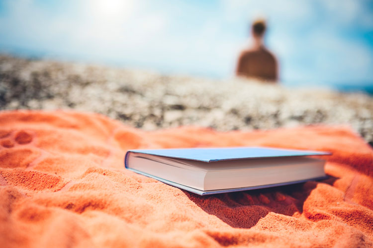Book on towel on beach