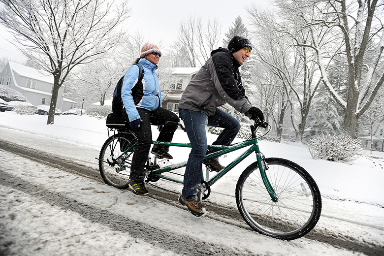 Couple riding tandem bike in the snow