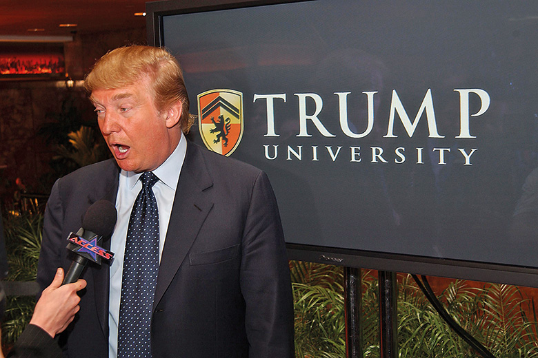 Donald Trump next to Trump University sign