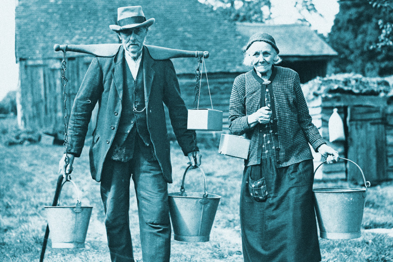 Elderly couple carrying buckets of water