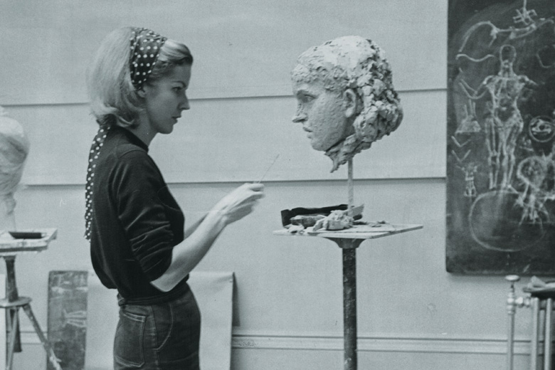 Female artist working on bust head sculpture