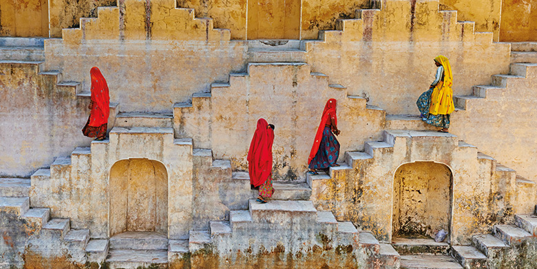 Four Indian women walking up and down staircases