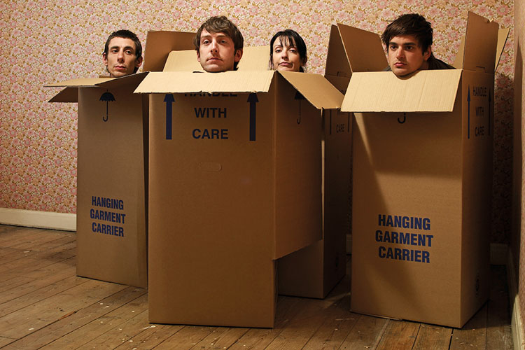 Four people sitting in cardboard boxes