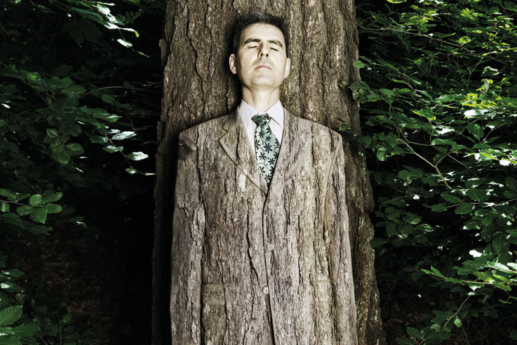 Man camouflaged against tree bark