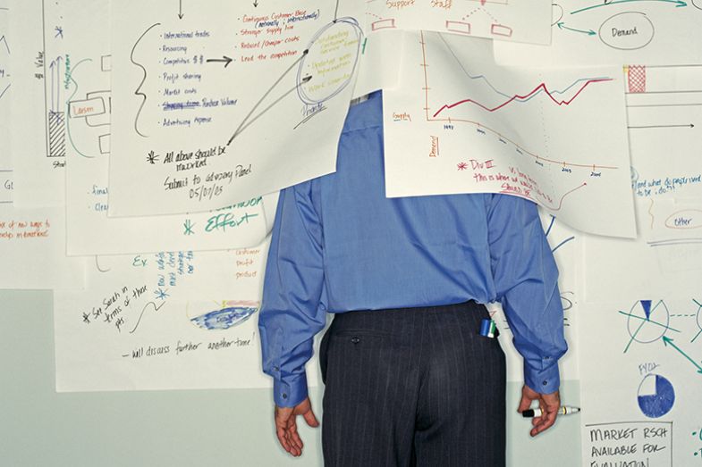 Man partially covered with charts