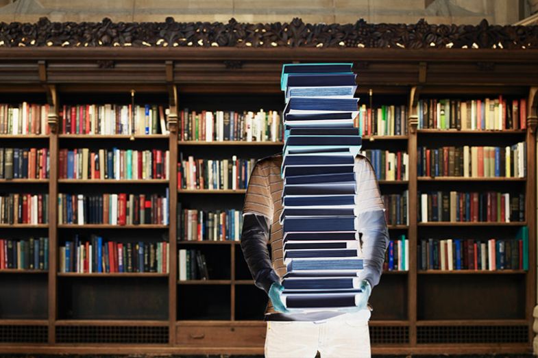 figure holding stack of books