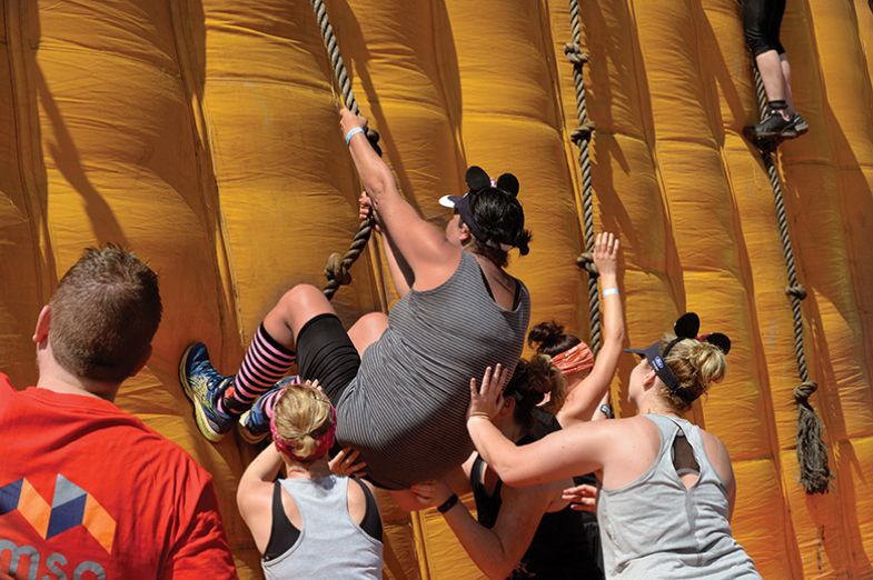 Contestants climb an inflatable wall during the Strongman obstacle race in 2019, in Paarl, near Cape Town. Symbolising helping up black postgrads