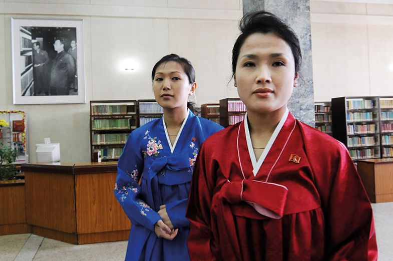 North Korean librarians next to a portrait of Kim Jong-Il