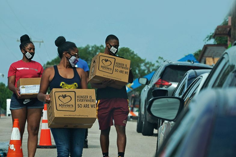 Volunteers deliver food to cars at a Covid-19 testing site at Paul Quinn College in Dallas, Texas on 29 July 2020