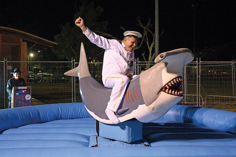 Man in sailor uniform riding mechanical shark