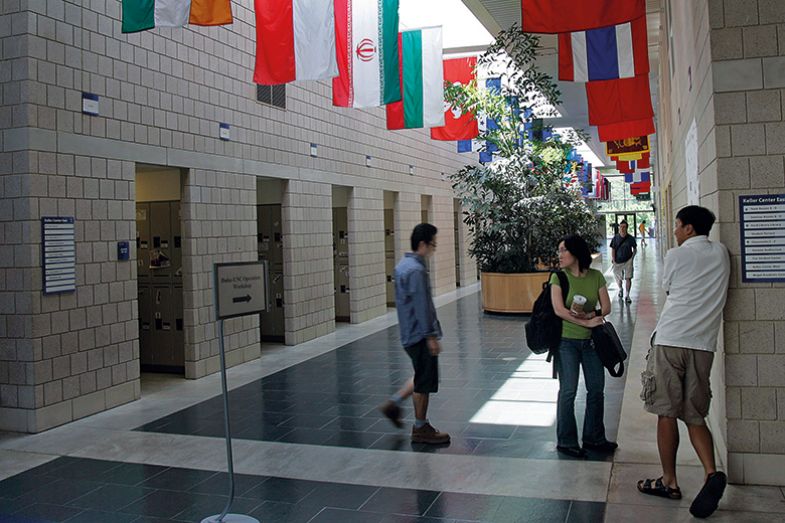 Students standing underneath flags in corridor