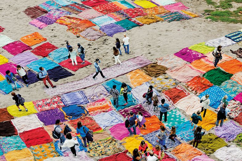 Montage of people walking over saris on beach