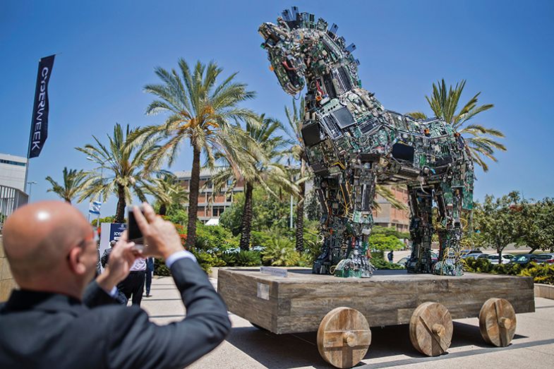 A man photographs ‘Cyber Horse’, a replica of the Trojan horse by ‘No, No, No, No, No, Yes’ and made of computer and mobile phone components infected with viruses and malware, Tel Aviv, 2016