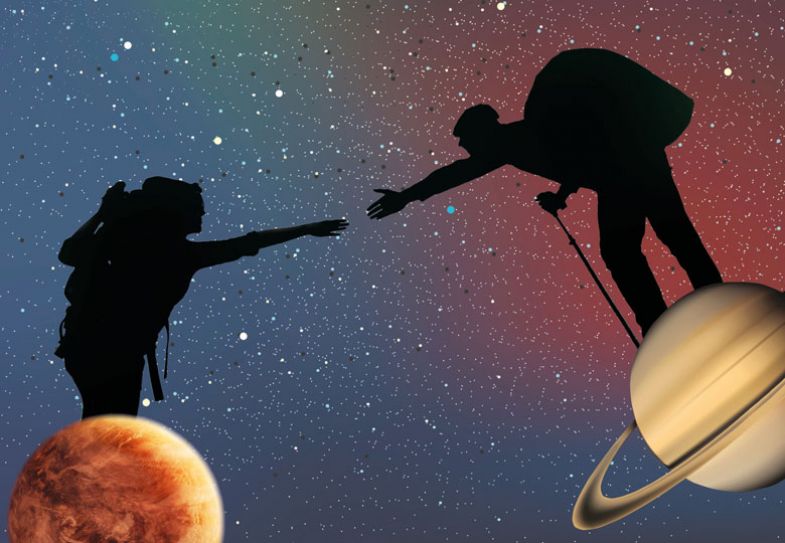 Silhouette of two people reaching out to each other, each standing on a different planet.