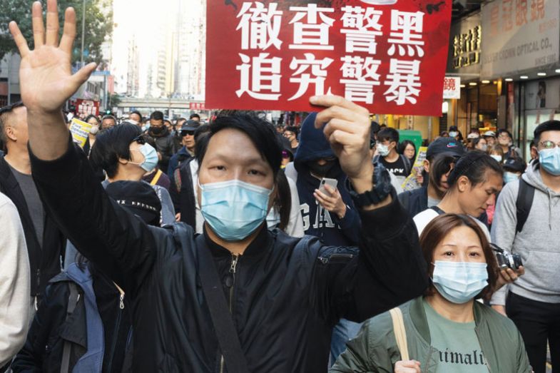 Pro-democracy protesters march on a street as they take part in a demonstration on December 8, 2019 in Hong Kong, China to describe up to 2019 the mask was a symbol of resistance, worn by protesters