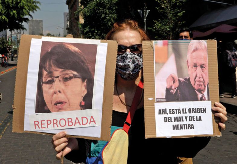 Protestor holding banners during a demonstration to demand the resignations of Maria Elena Alvarez - Buylla and Jose Antonio Romero Tellaeche