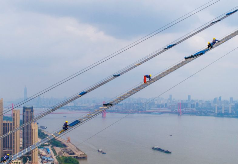 A drone shows workers labouring on the construction of a double-deck suspension bridge crossing the Yangtze River in Wuhan in China's central Hubei province