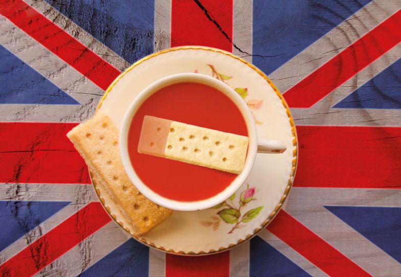 The Union Jack flag with a cup of tea served with a shortbread biscuit 