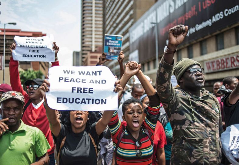 South African a student holds a placard reading 'We want peace and free education' during a protest in Pretoria
