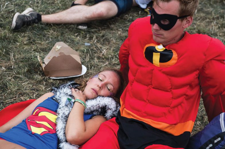 A woman dressed as Superwoman sleeps next to her partner dressed as Mr Incredible as a metaphor for unwinding the madness 