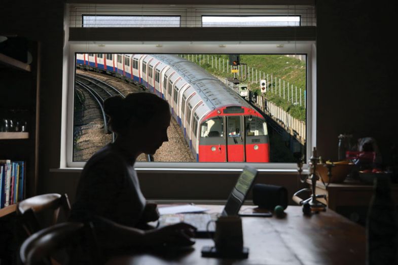 Person from home with a tube train outside the window.