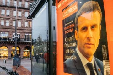 Portrait of French President Emmanuel Macron on the cover of L'Express interview advertising at press kiosk