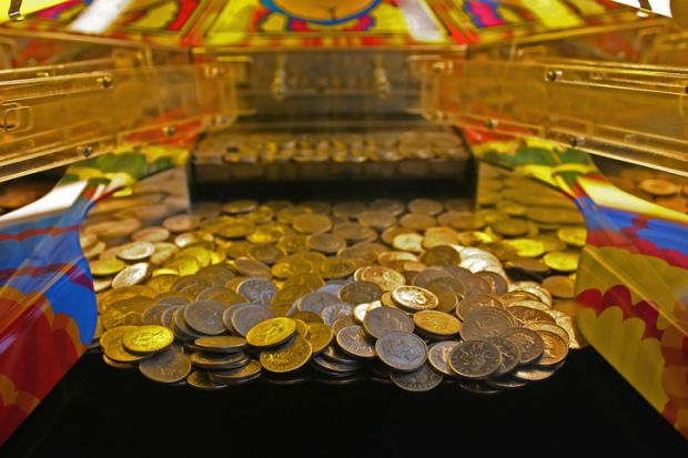 A 10 penny falls arcade machine with focus on the line about to fall. Weston Super Mare, UK.