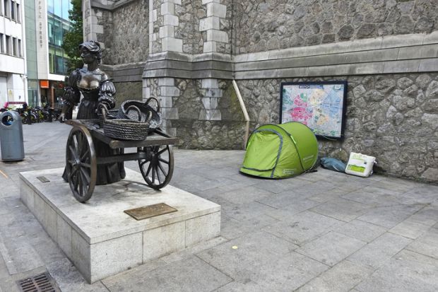 A homeless person's tent beside the iconic Molly Malone bronze statue in Suffock Street, Dublin City Centre