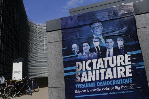 A poster of anti-vax movement in front of Berlaymont Building, the European Commission headquarters in the European district of Brussels, Belgium on April 19, 2021. stock photo