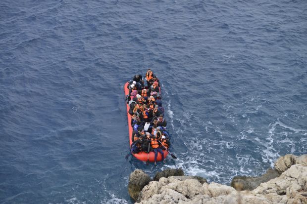 An inflatable boat filled with refugees and other migrants approaches the south coast of the Turkey