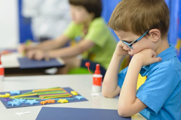Angry kid looking at his craft at kindergarten