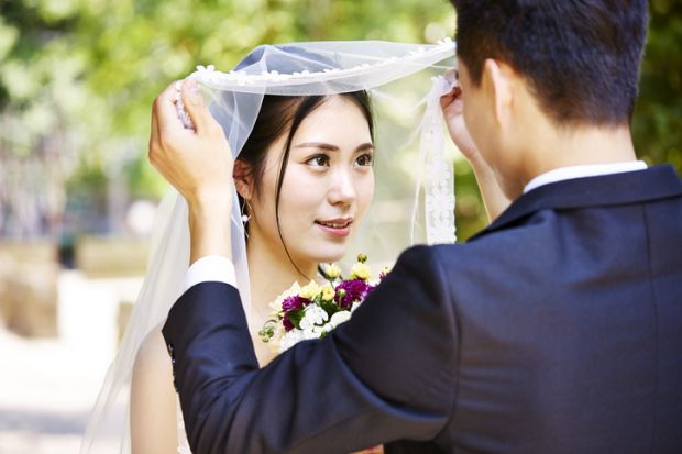 Asian bride and groom illustrating article about a Chinese province organising speed-dating events to encourage graduates to stay in the region, match-making, marriage