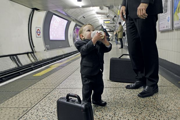 Man and little boy wearing suits standing on tube platform