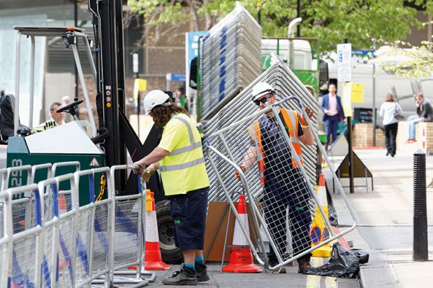 Construction workers erecting barriers