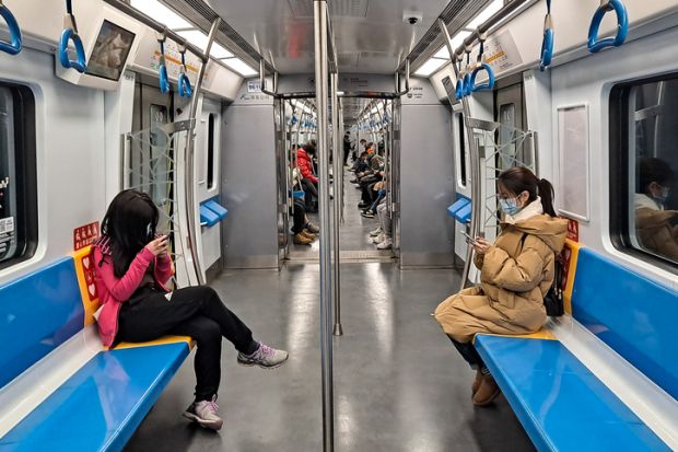 Beijing, China - Feb 1, 2022 Only a few passengers with face masks travel in a subway during coronavirus crisis in Beijing.