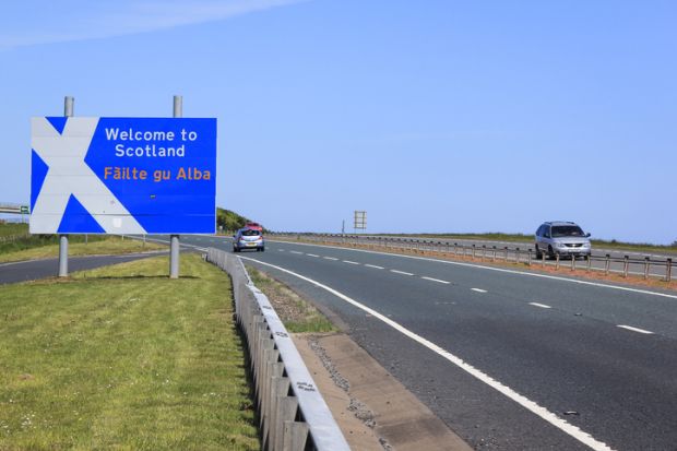 Berwick, UK - May 31, 2010 Cars on the A1 main road crossing the border between England and Scotland, passing the Welcome to Scotalnd sign with a stylised Saint Andrew's Cross scottish flag. Borders in the UK are open with no controls and free movement.
