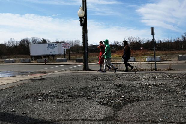 Three people walking on deserted street in Binghamton NY