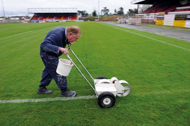 Man painting lines on a pitch