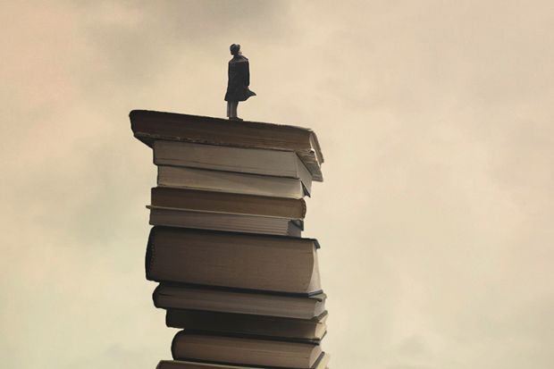 Person standing on tower of books