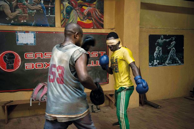 Boxers spar in gym, one of them blindfolded