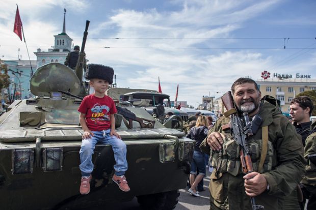 Boy sitting on armoured personnel carrier, Luhansk, Ukraine, 2014