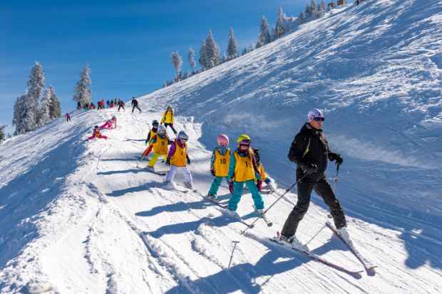 Brasov, Romania - December 10, 2018 Group of children with ski instructor on the slope in a sunny day in Poiana Brasov resort