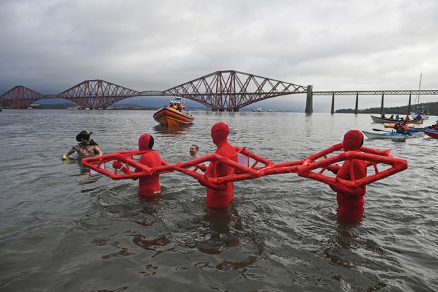 People in water pretending to be a bridge
