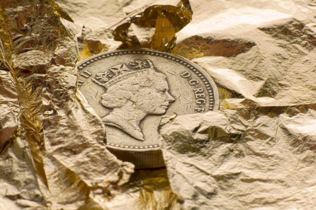 British pound coin on gold leaf