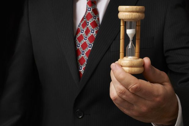 Businessman holding an egg timer