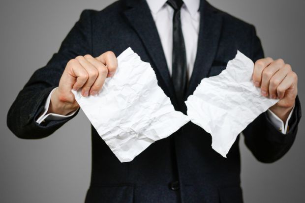 Businessman tearing hands crumpled sheet of A4 paper