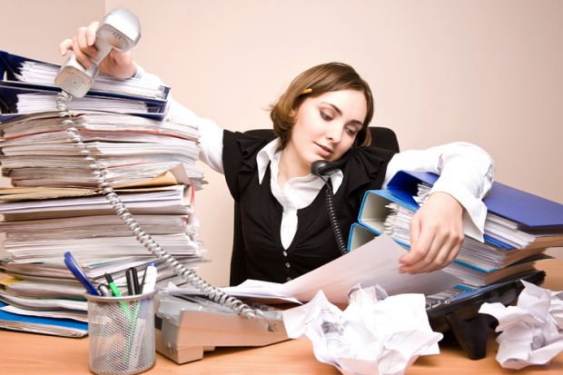 Businesswoman working at cluttered desk