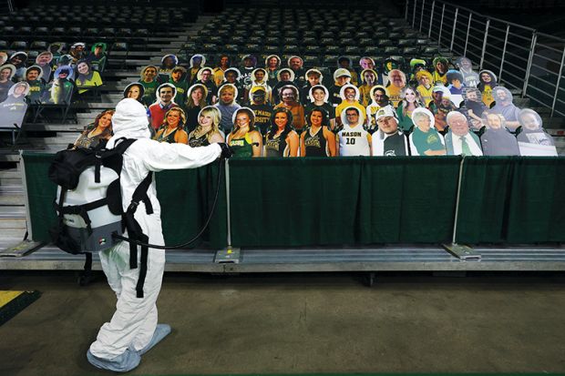 Man in PPE with audience of cardboard cut-out people, virtual conference, digital, remote