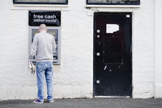 Govan, Glasgow / UK - August 31st 2019: Male person at cash point machine ATM automated free money withdrawal in wall
