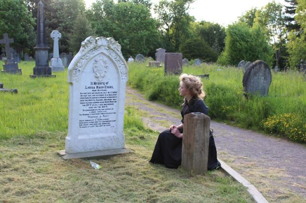 Students perform in a cemetery